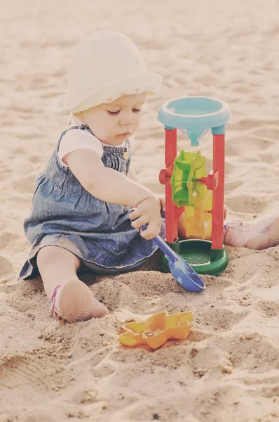 Küçük kız kumda oyuncak oynuyor. — Stok fotoğraf
